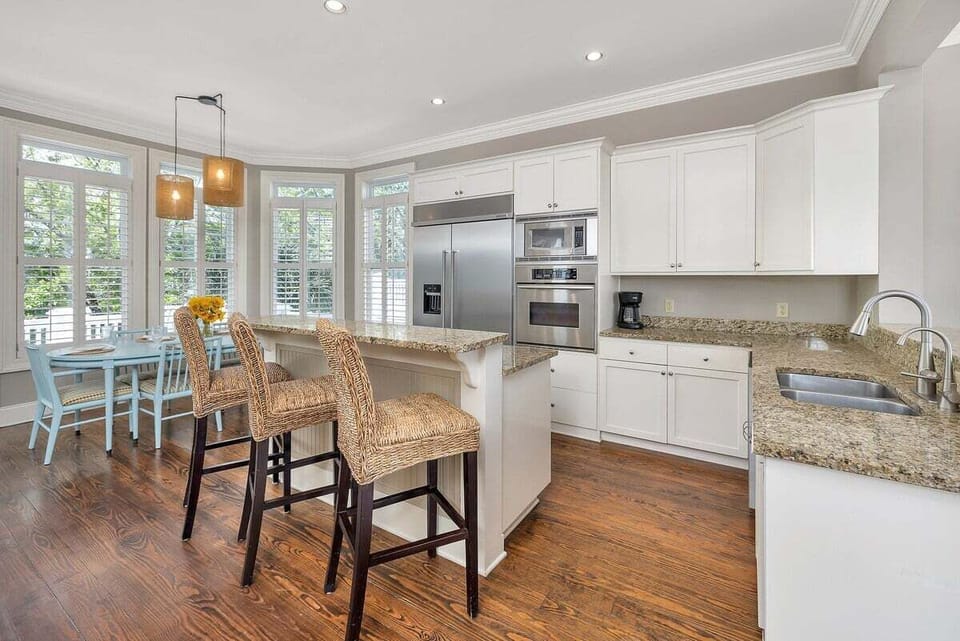 Alternate view of modern kitchen with stainless steel appliances and island seating