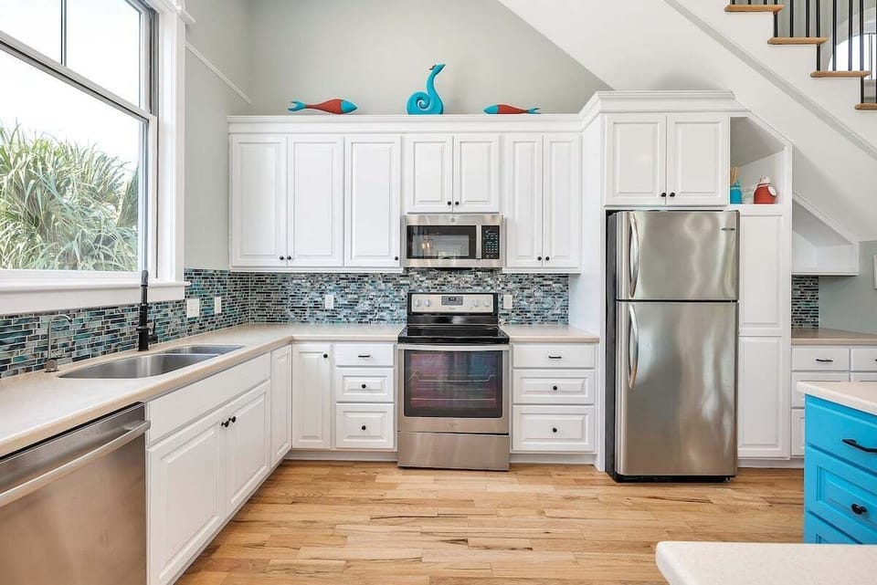 Kitchen with stainless steel appliances and white cupboards