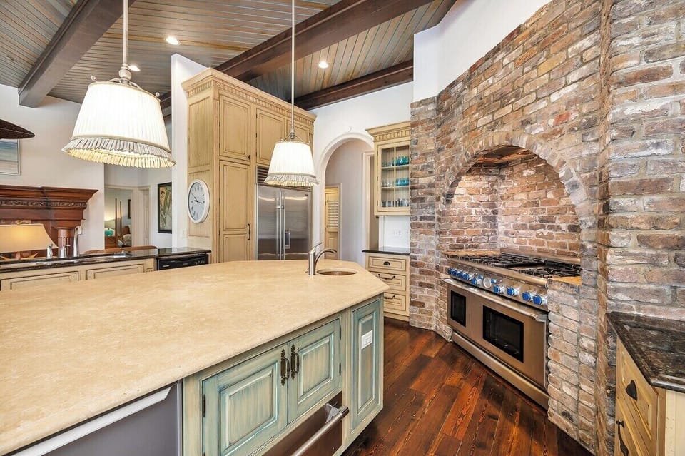 Alternate view of rustic brick arched kitchen alcove and island