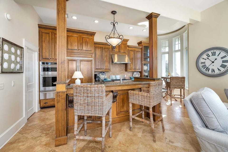 Kitchen with wood cabinetry, island, and bar seating