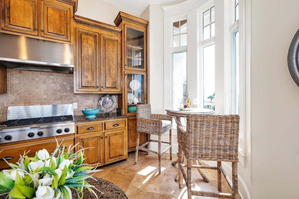 Kitchen with wood cabinetry, granite counters, and wicker seating