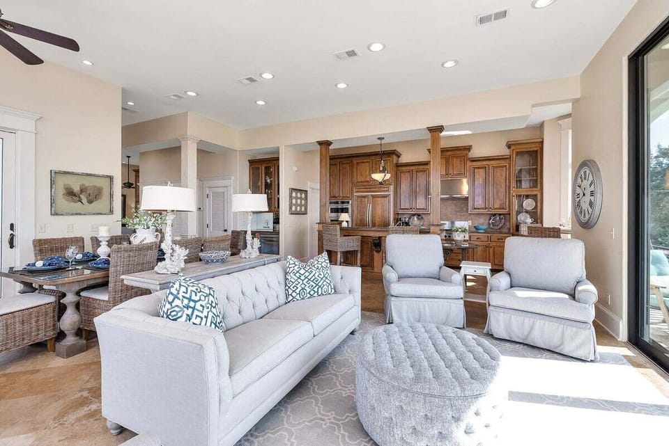 Living room with white sofa, blue accents, and kitchen view