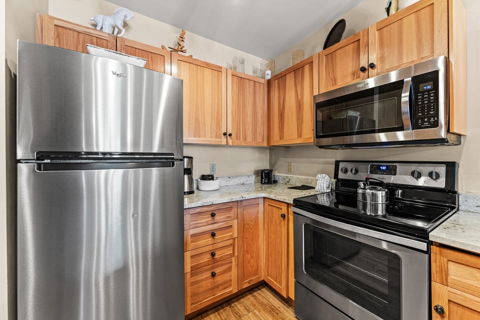 Cook your favorite meals in this fully equipped kitchen with stainless steel appliances and warm wood cabinets.