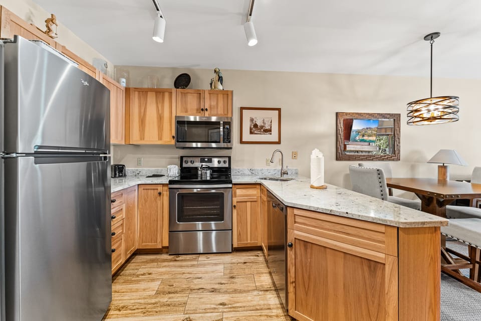 Your fully equipped kitchen features warm wood cabinets, granite counters, and modern stainless appliances for all your culinary needs.
