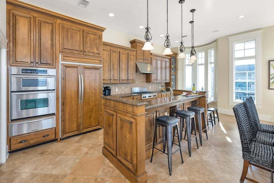 Wood kitchen with double ovens, island, and bar seating