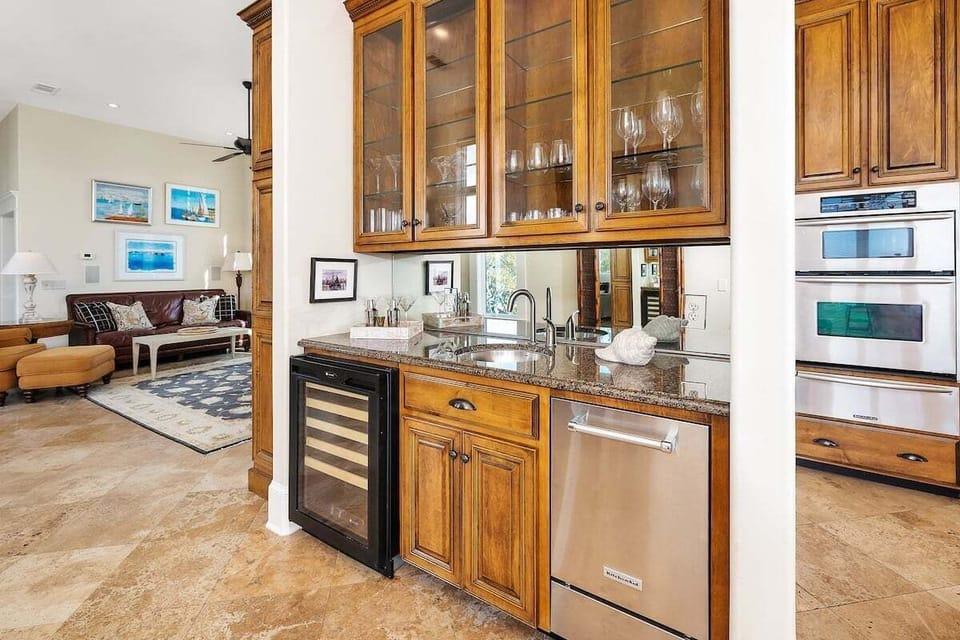 Built-in bar with wood cabinetry, wine fridge, and appliances