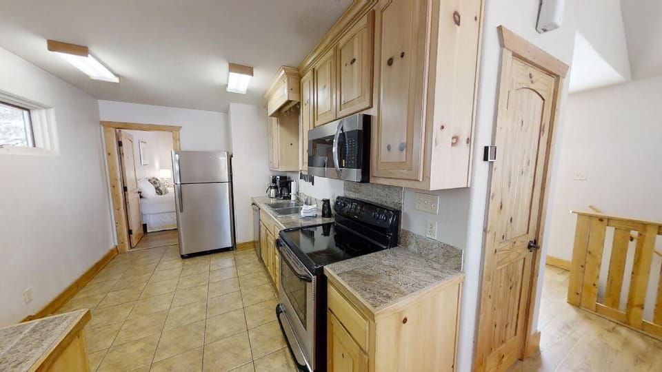Cook meals your way in this fully equipped kitchen, featuring stainless steel appliances, granite counters, a microwave, coffee maker, and ample cabinet space for all your vacation essentials.