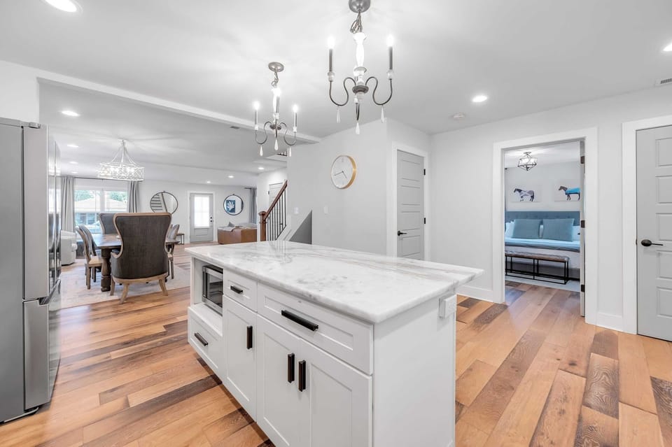 Cook
at the island
while the
dining table
and wingback
chairs stay in
view — a
bedroom door
cracked open
in the
background
shows just
how
connected this
whole floor is.