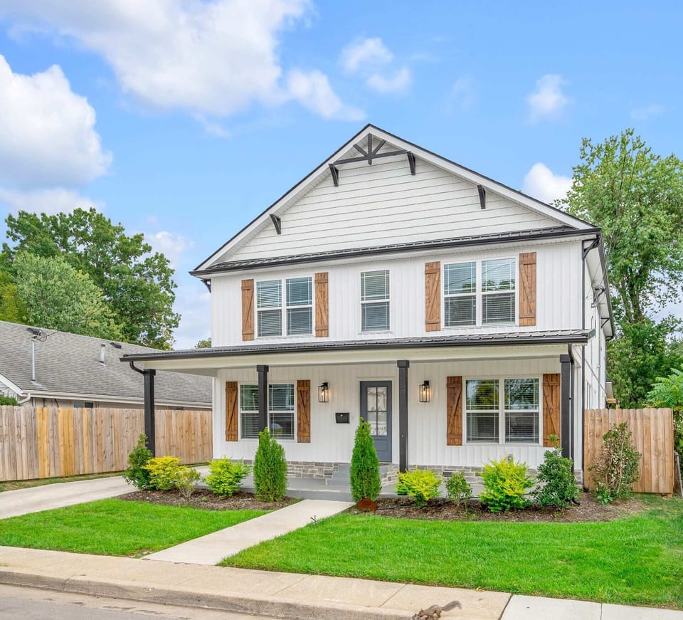 Drive
up for the full
reveal — two
stories of
board-andbatten siding,
a porch
running the
width of the
house, and a
stone
foundation
that means it's
built to last.