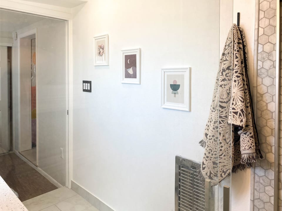 Bathroom with tub/shower, marble tile walls, tankless/instant hot water heater