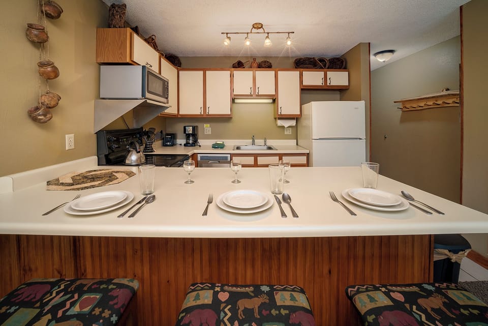 Your fully equipped kitchen features everything needed for cooking, with a breakfast bar perfect for morning coffee.