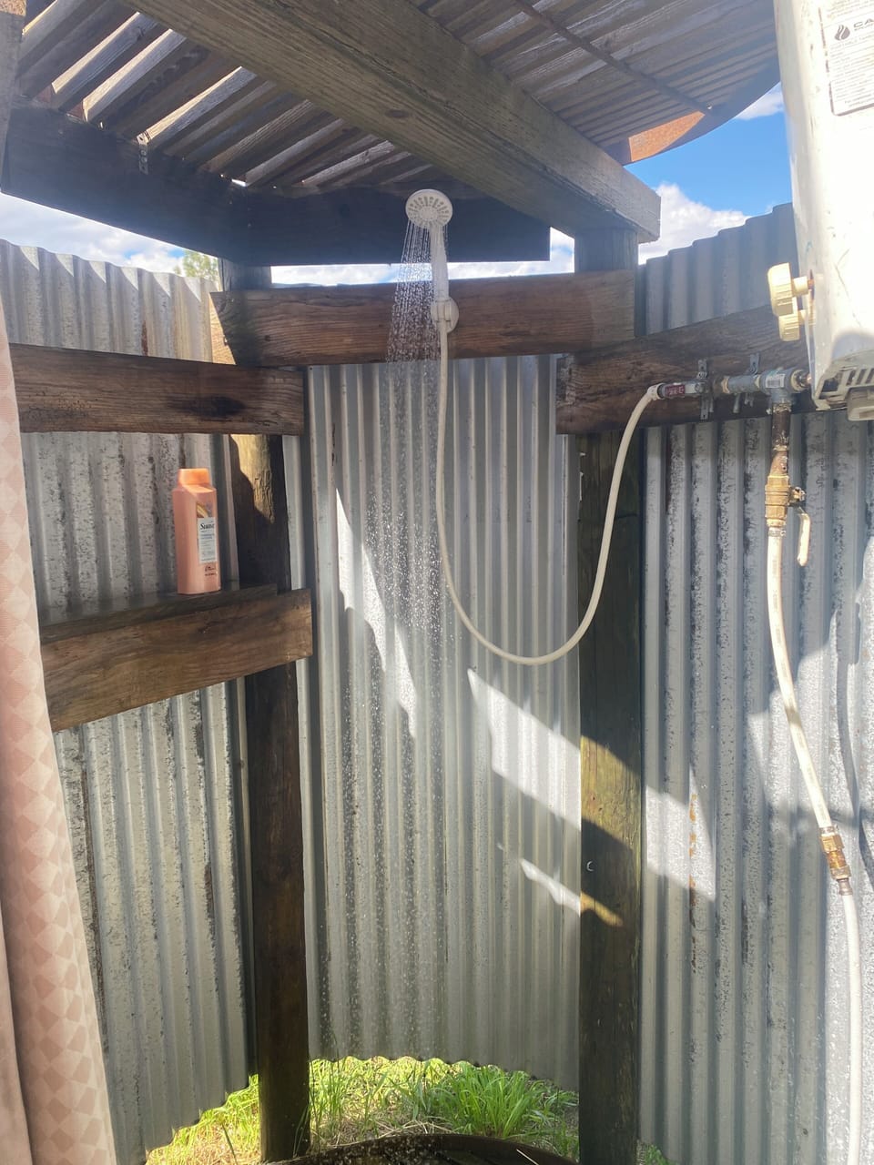 The outdoor shower is a unique handmade design with an on-demand hot water heater
