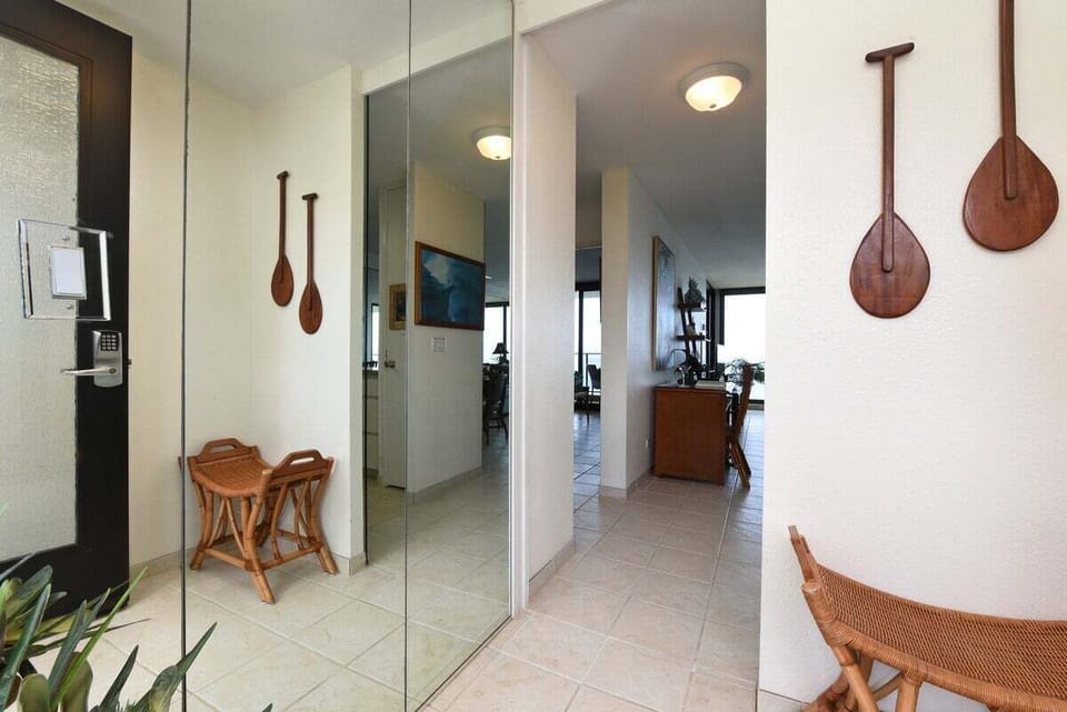 Bright hallway with mirrored walls and tasteful island-inspired décor, creating a warm and inviting entrance to your vacation retreat