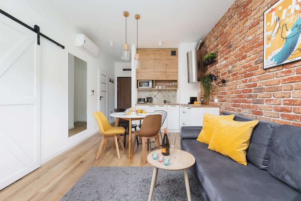 Living room with double sofa bed, TV, access to the balcony and kitchenette.
