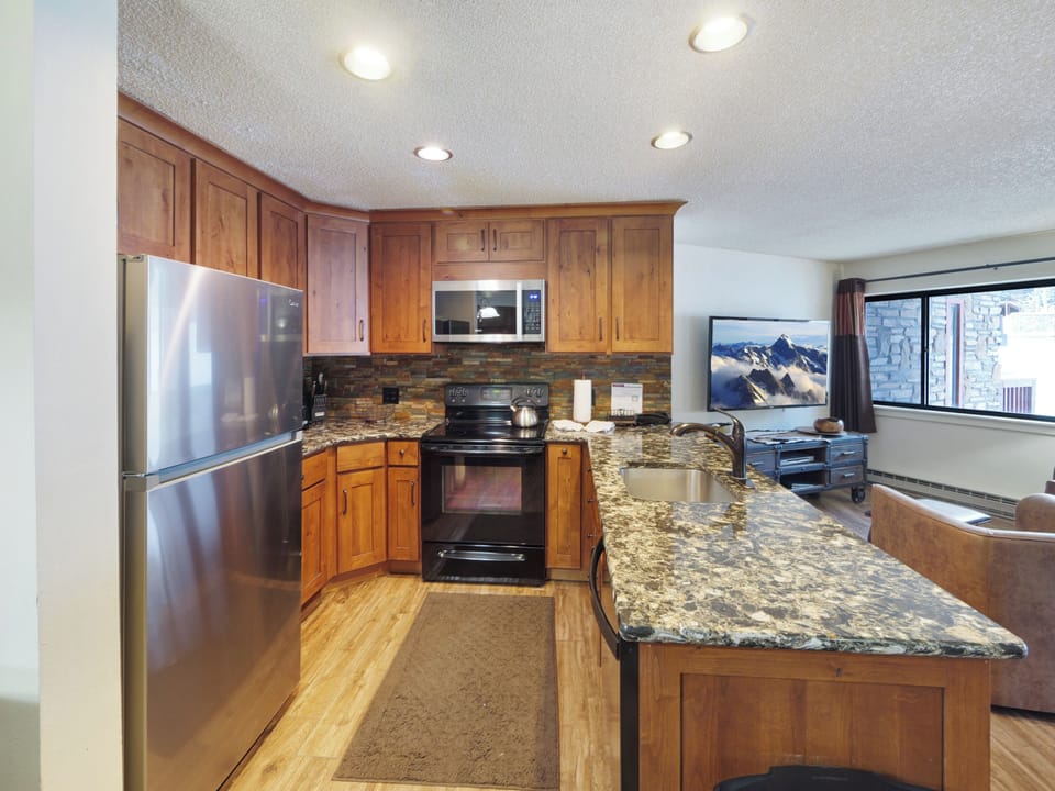 Your gourmet kitchen features granite counters, stainless appliances, and cherry cabinets - perfect for preparing meals after mountain adventures.