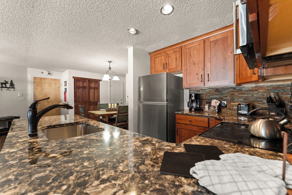 Cook with ease in your beautiful kitchen featuring granite counters, rich wood cabinets, and modern stainless appliances perfect for memorable meals.