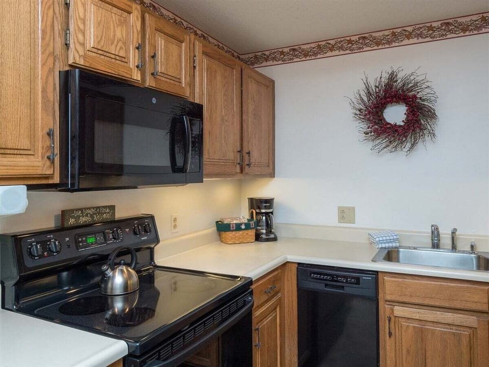 Kitchen is stocked with dishes, silverware and pots/pans
