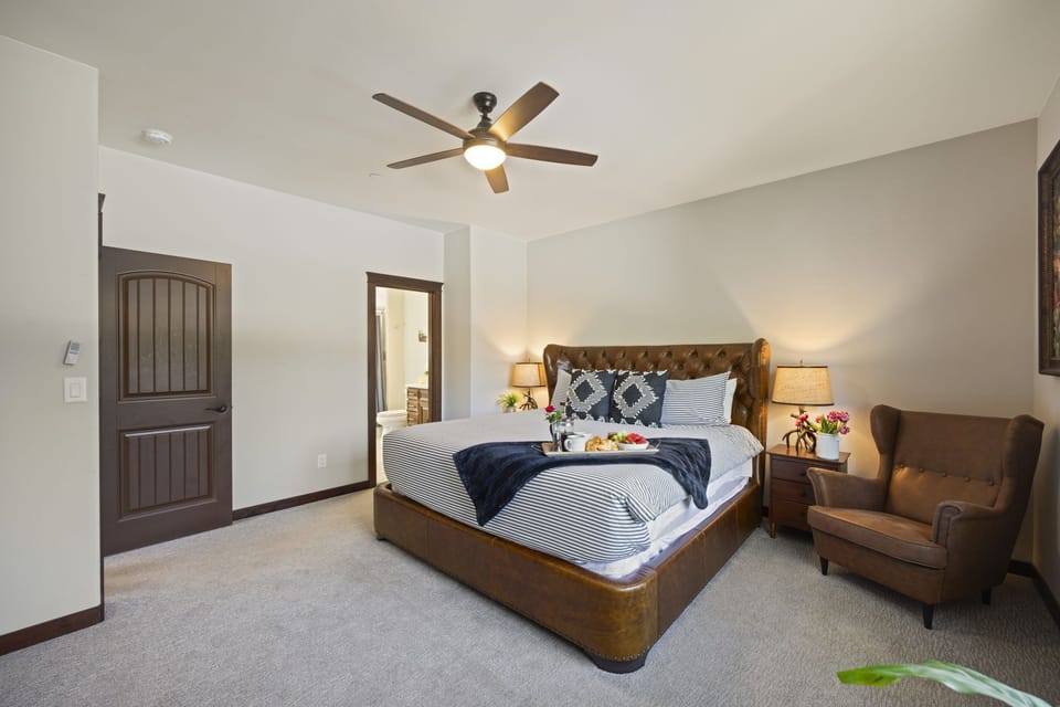Upper Floor - Bedroom 3, Tufted leather king bed frame, plush bedding, and morning light filtering through wood-framed windows