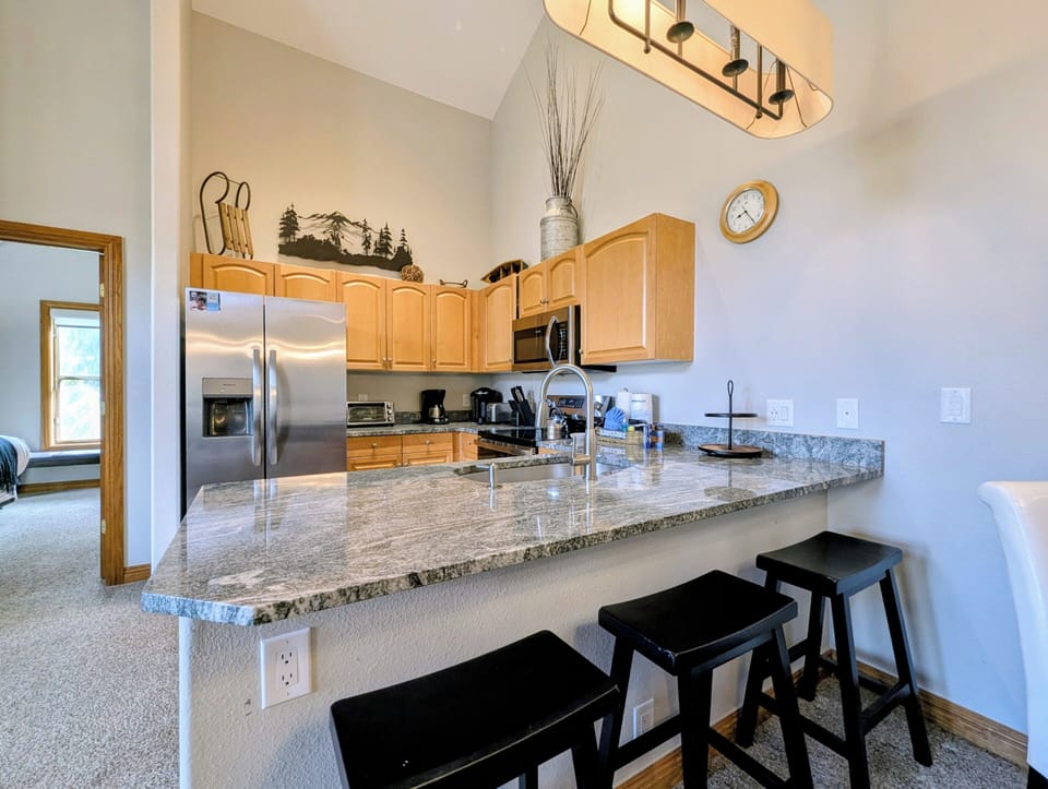 Your fully equipped kitchen features granite countertops, stainless appliances, and breakfast bar seating for casual dining.