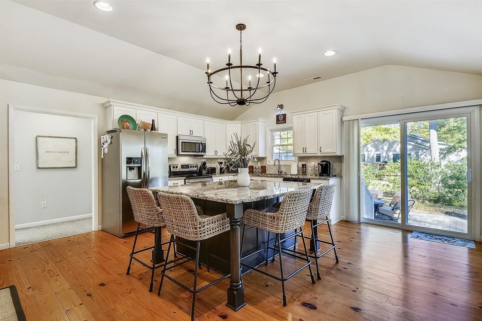 607 Sandstone Court - Vaulted Kitchen with Outdoor Access - This angle highlights the home's open floor plan, with the kitchen leading directly toward sliding glass doors that open to the outdoor living area. The vaulted ceiling creates a sense of grandeur in the heart of the home.