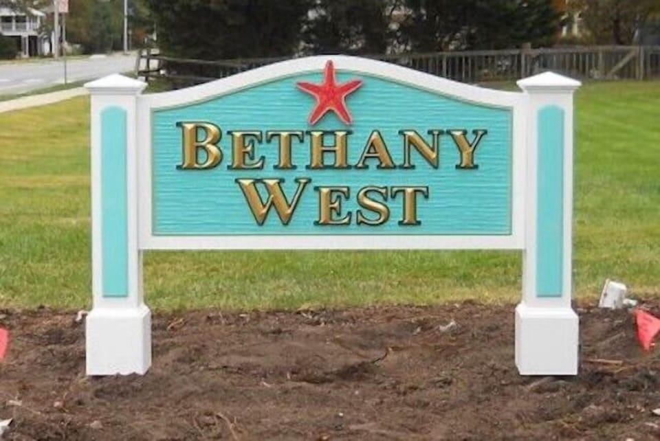 607 Sandstone Court - Bethany West Community Signage - The entrance to the neighborhood is marked by a distinctive teal and white sign, welcoming residents to the Bethany West community. The community is known for its quiet streets and proximity to downtown Bethany Beach.