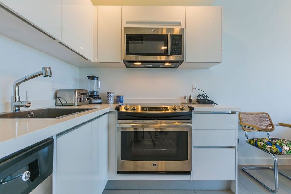 Your bright, modern kitchen is equipped with stainless steel appliances, sleek cabinetry, and ample counter space for preparing your favorite meals during your stay.