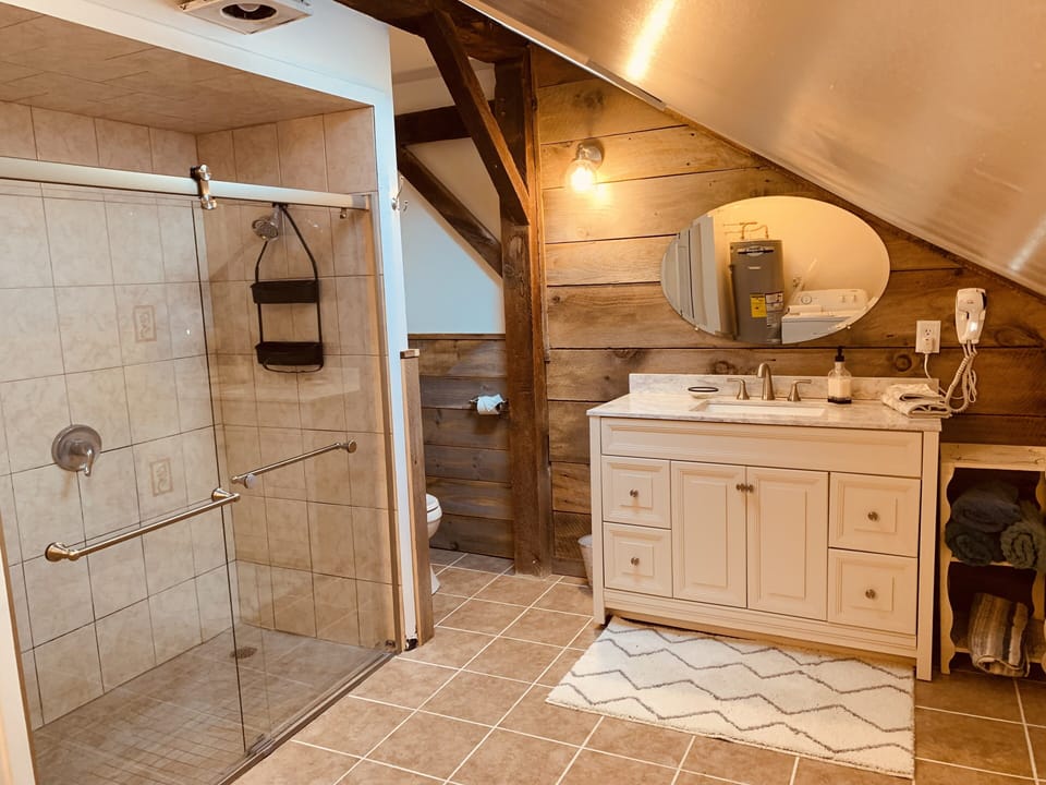 Main Bathroom with 5’ walk- in shower, glass doors and washer/dryer