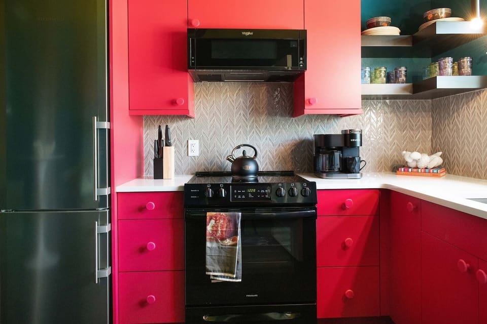 Bold kitchen with sleek appliances and vibrant cabinetry for a fun, stylish twist
