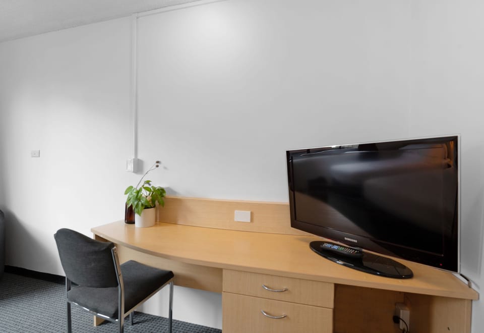 Desk, iron/ironing board, bed sheets