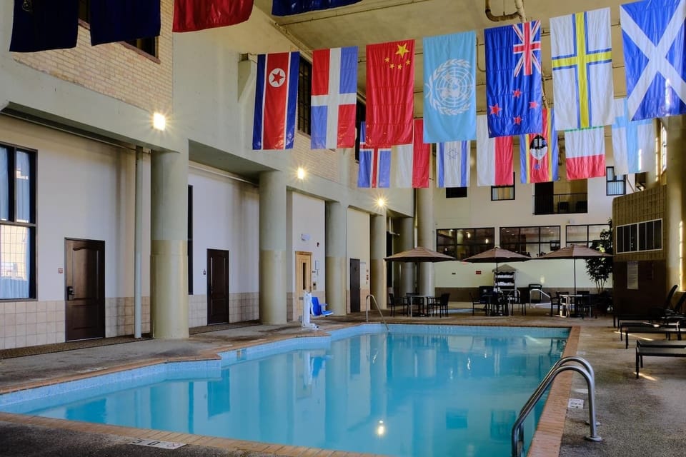 Spacious hotel pool area offering spots to swim, stretch & relax.