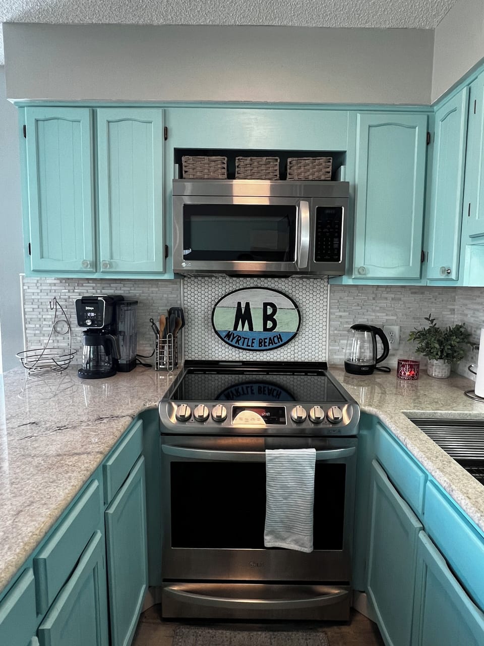 Kitchen with stove, microwave, coffee pot and kettle