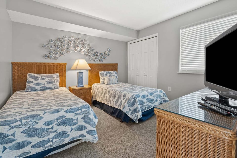 Two beds with blue and white bedding at Ocean Bay Club 604, a 4-bedroom Ocean Drive vacation rental