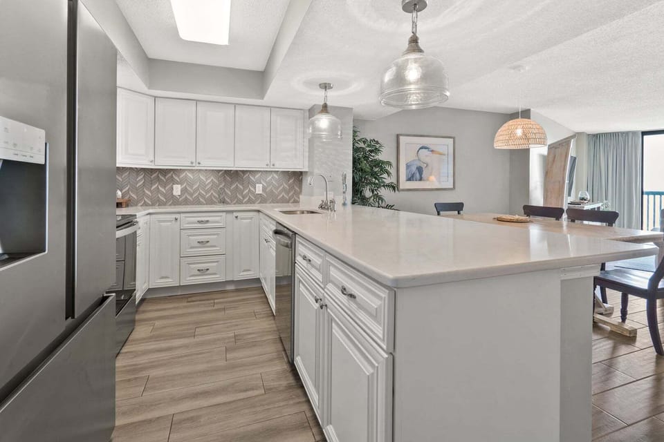 White cabinetry and pendant lights above the island at Ocean Bay Club 604, a 4-bedroom Ocean Drive rental