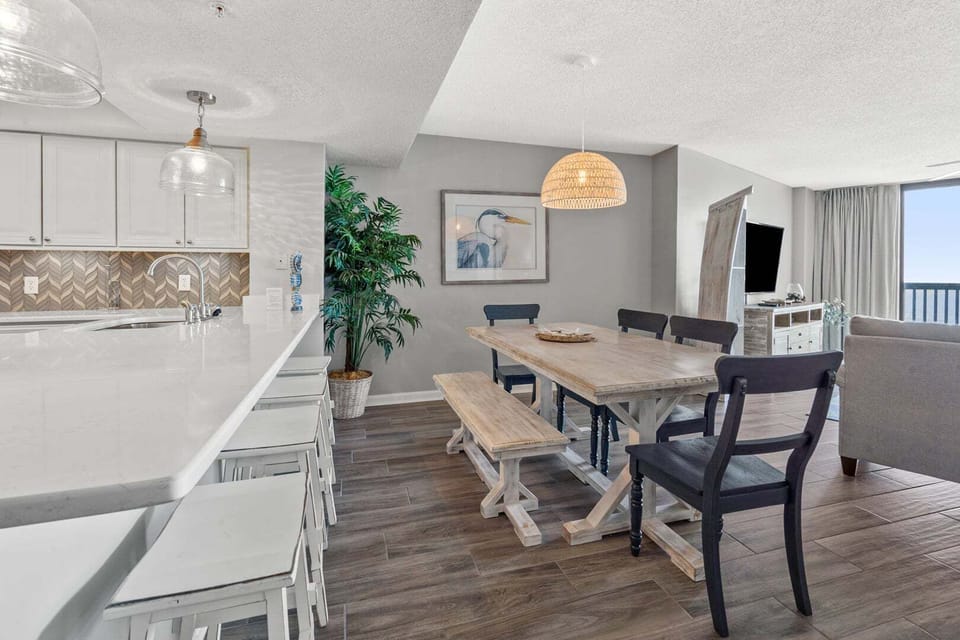 Dining table with bench seating beside the kitchen island at Ocean Bay Club 604 in Ocean Drive