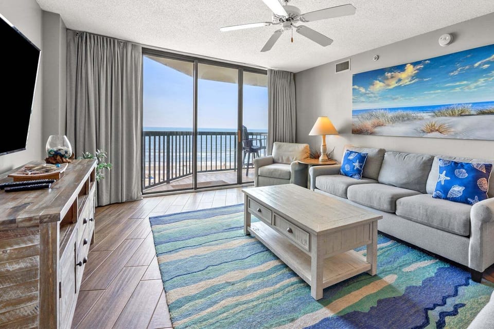 Living area with beach artwork and a wall-mounted TV at Ocean Bay Club 604 in Ocean Drive, North Myrtle Beach