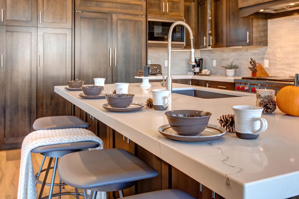 Fully equipped, kitchen with stone countertops, stainless steel appliances with stovetop, fridge, and island