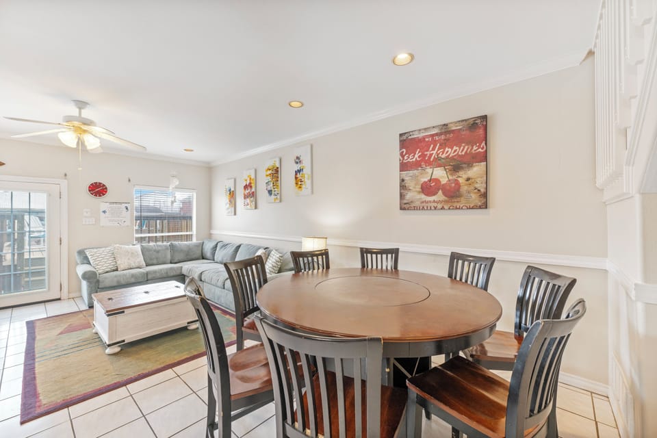 Gather around the spacious dining table for memorable meals while relaxing on the comfortable sectional sofa nearby.