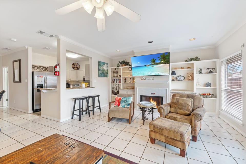 Unwind in your open-plan living space with cozy fireplace, large TV, and stylish kitchen—perfect for relaxing after your adventures.