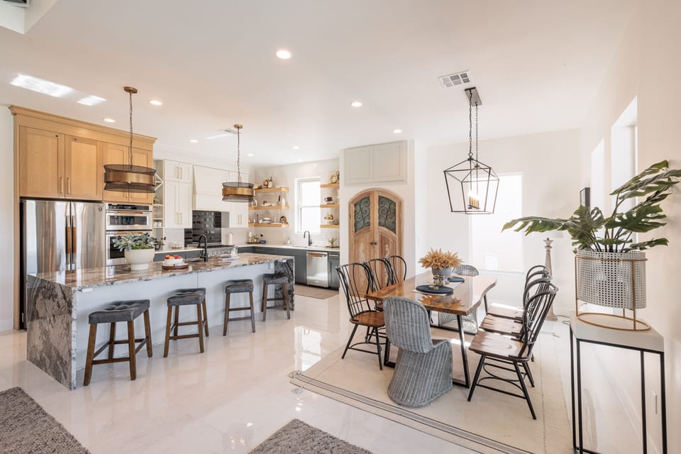 Kitchen & Dining Room View - The kitchen is fully stocked with all the dishes, cookware, baking pans, and cutlery you will need for meal preparations and includes stainless steel appliances and marble counter tops.