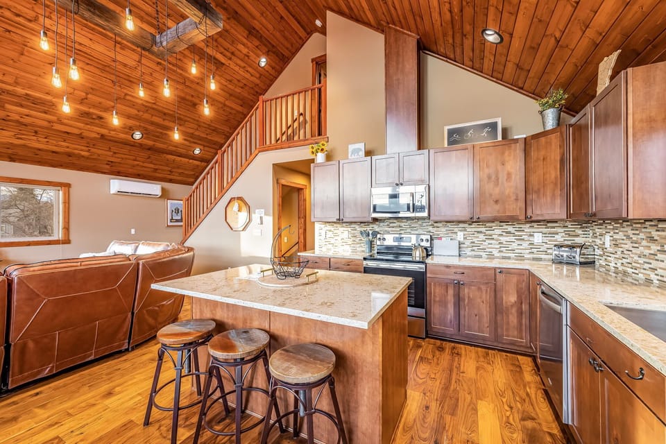 Fitted kitchen with center island and bar stool and high end kitchen appliances