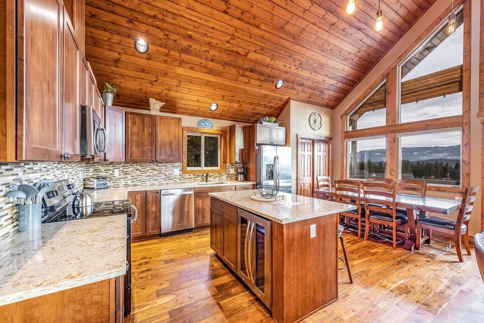 Fitted kitchen with center island and bar stool and high end kitchen appliances