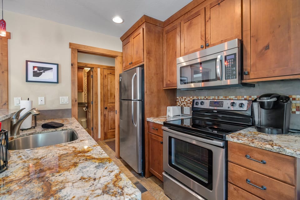 Remodeled galley kitchen w/stainless steel appliances and granite counter tops