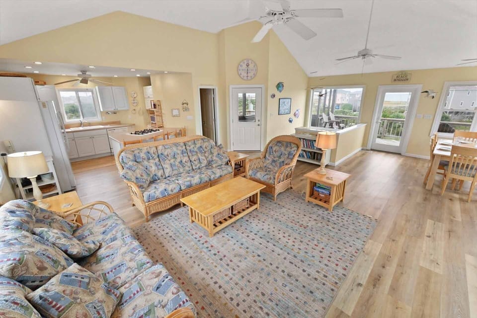 The upper level great room encompasses the living area, kitchen, dining area, and direct access to the decks.