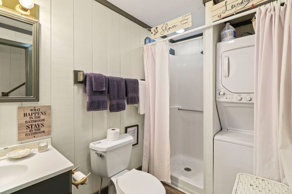 updated downstairs bathroom, includes: walk in shower stackable washer dryer, starter toiletries, towels, hand soap, shampoo/ body wash