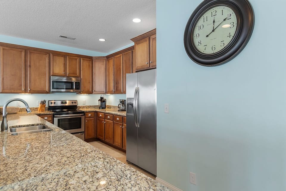 Your fully equipped kitchen features granite countertops, stainless steel appliances, and warm wood cabinets for memorable meal preparation.