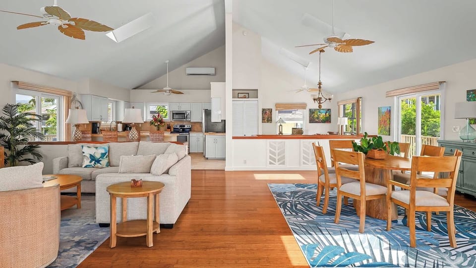 Relax in your spacious open-concept retreat where living, dining, and kitchen flow seamlessly together. Tropical breezes drift through as you unwind on the comfy sectional or gather around the dining table, surrounded by warm wood accents and island-inspir