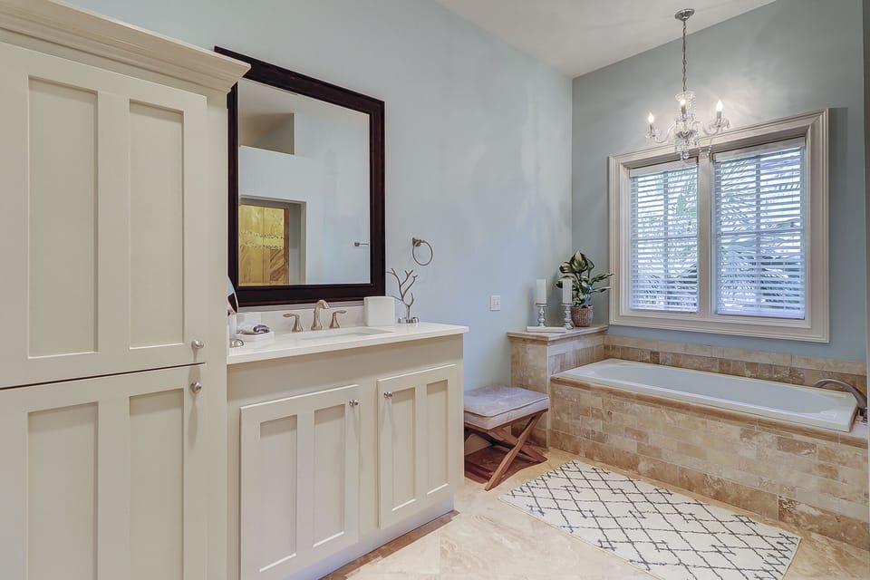 master bathroom with two separate sink vanities, large walk-in shower and soaking tub