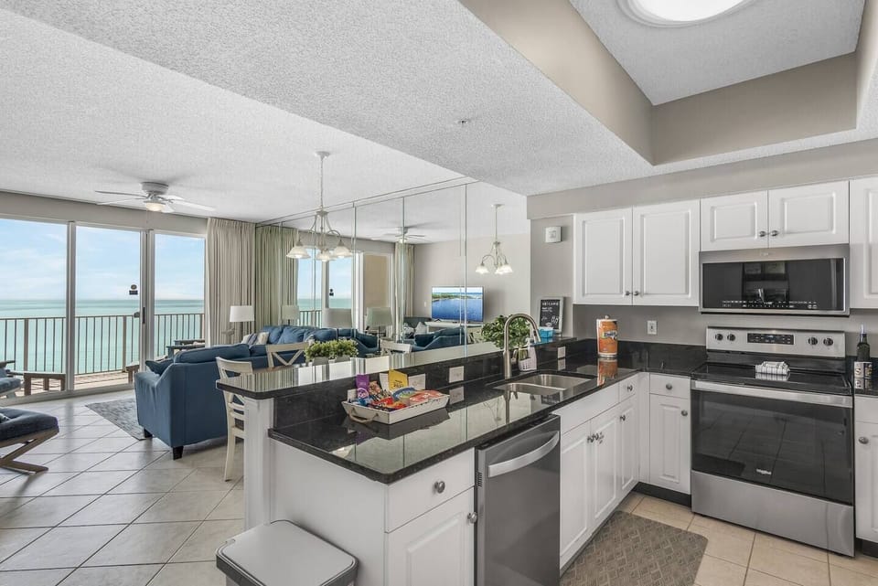 Kitchen is updated with granite countertops, stainless appliances, and is well stocked with all the cooking supplies needed for a home cooked meal + coffee and tea essentials. Prepare a meal with Gulf views!