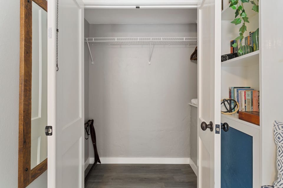 A large closet for your hanging clothes, and shelves with a variety of books.