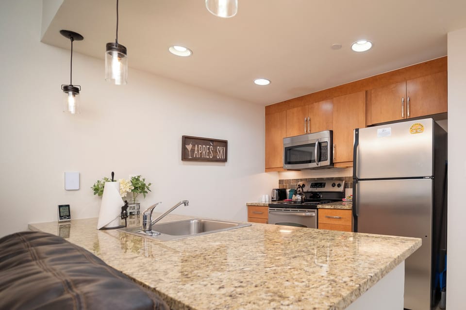 Your modern kitchen features granite countertops, stainless steel appliances, and warm wood cabinets perfect for preparing meals during your stay.